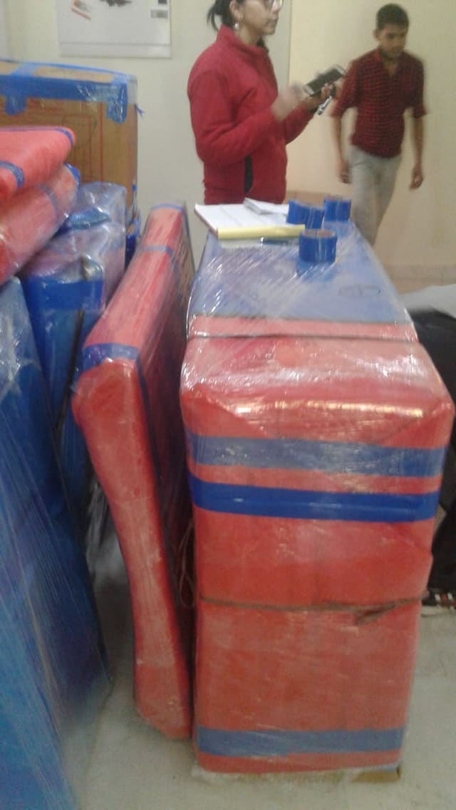 Wrapped office furniture and equipment staged during a commercial relocation