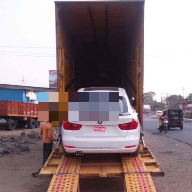 Car being driven up a ramp into an enclosed transport container