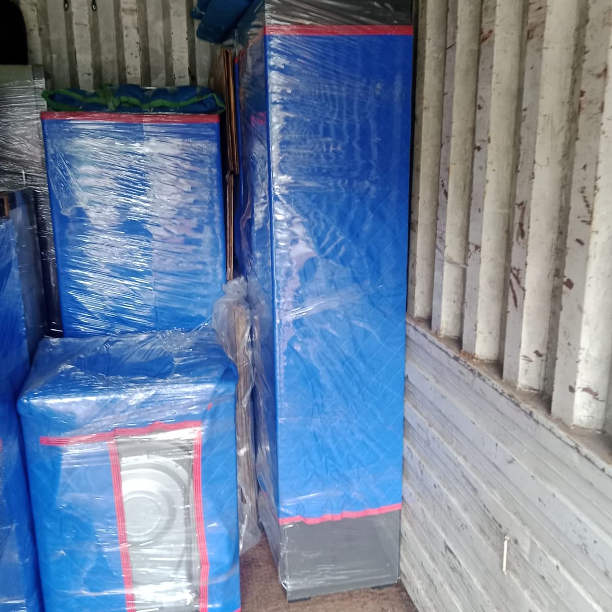 Wrapped household goods loaded and secured inside a transport container