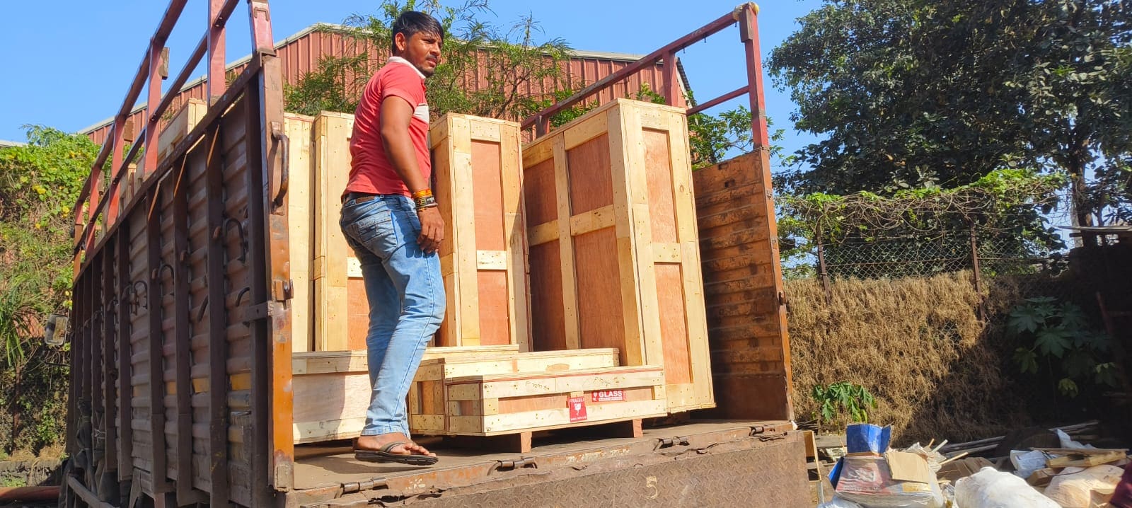 Crew member beside large wooden crates loaded on a transport truck