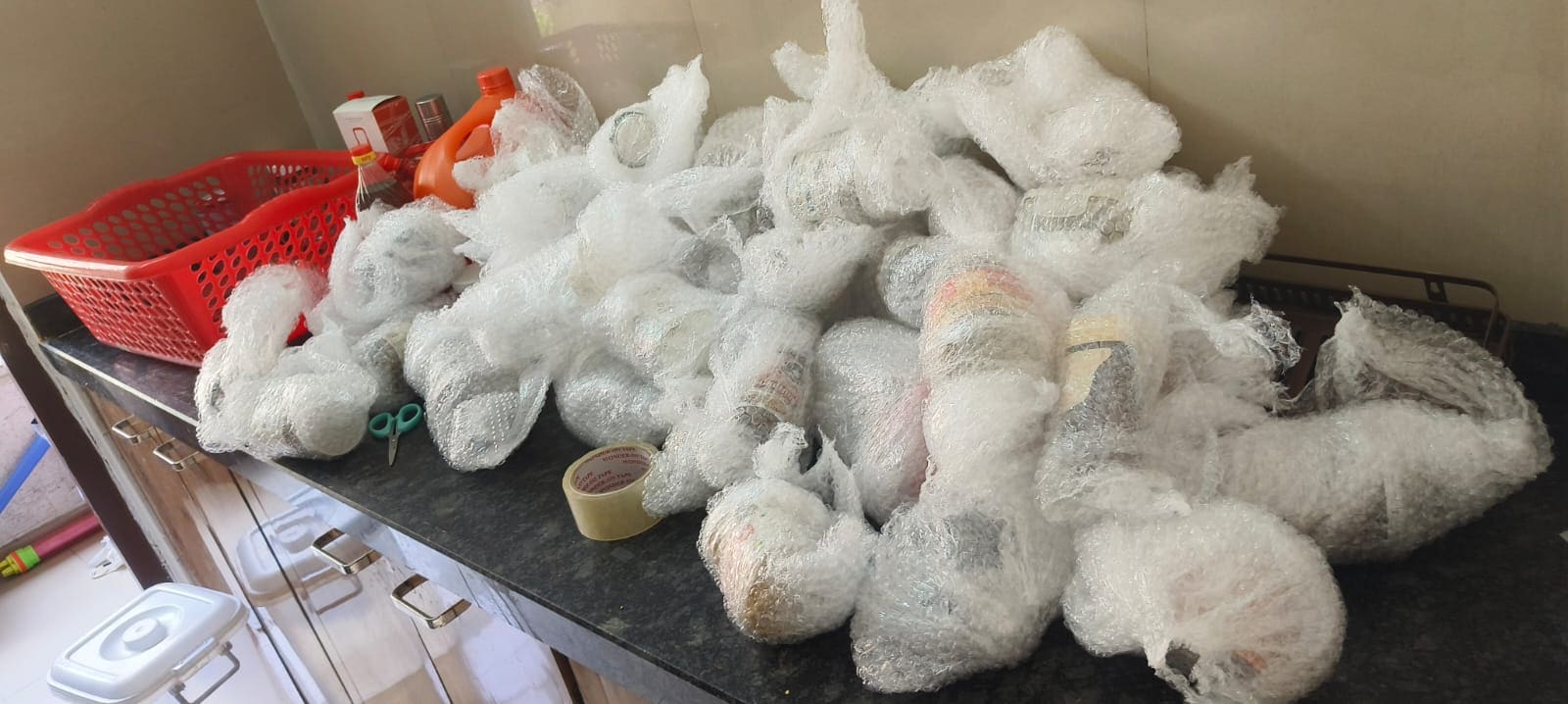 Kitchen crockery and utensils individually wrapped in protective material