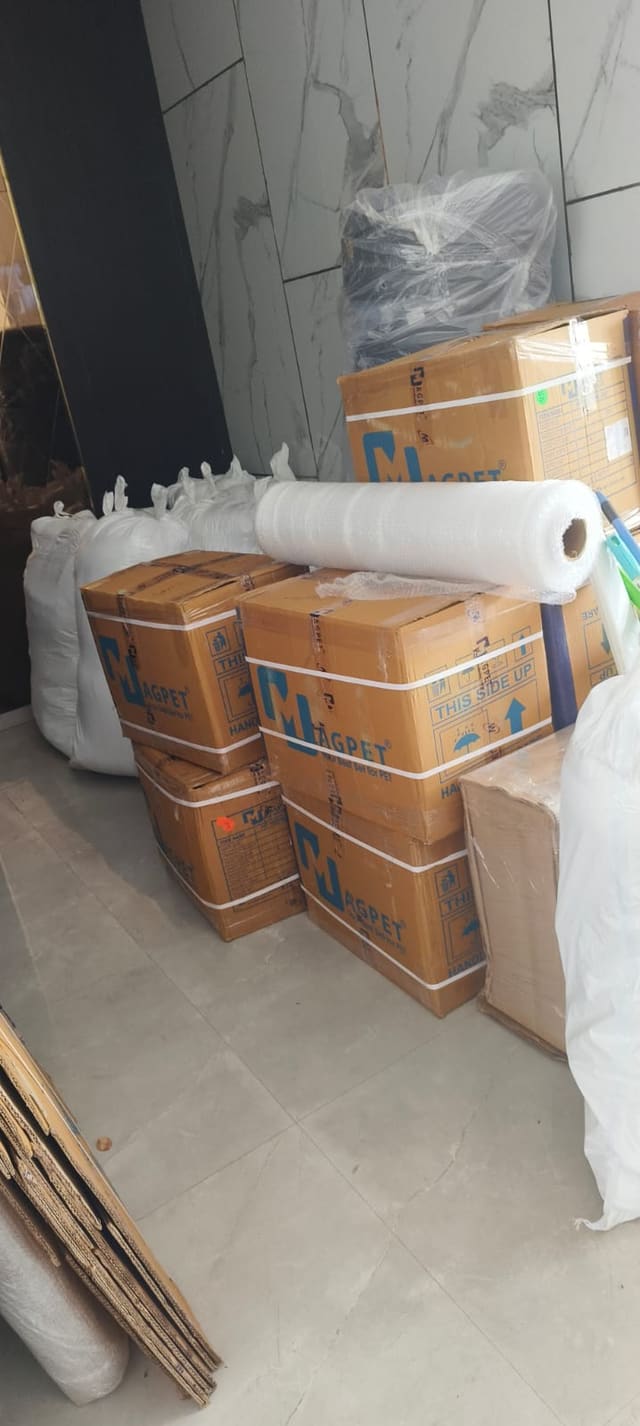 Packing cartons stacked beside rolls of protective wrapping material