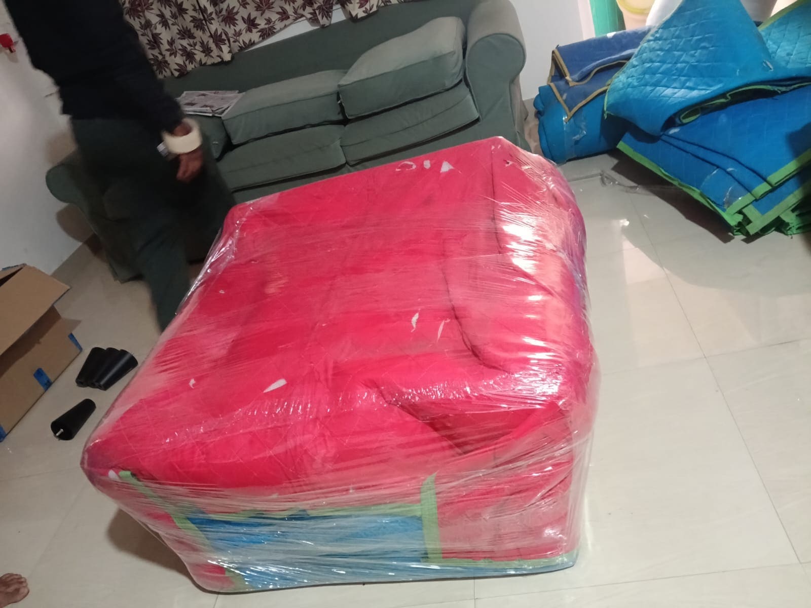 Sofa wrapped in protective sheeting on a floor during a household move