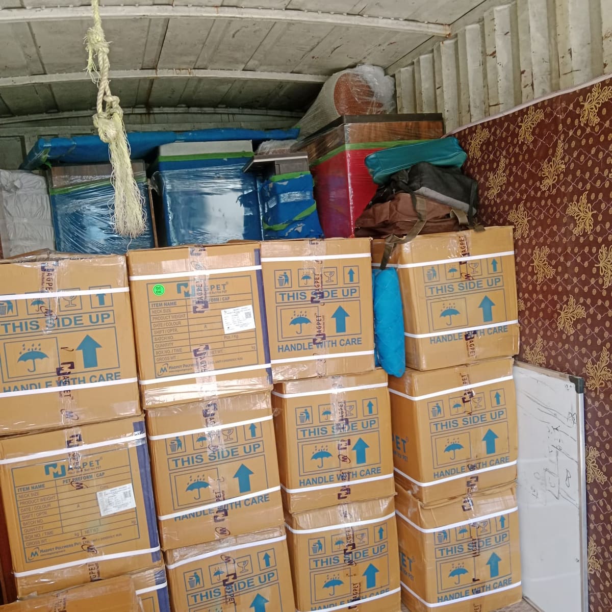 Moving truck interior packed with labelled cartons and wrapped goods