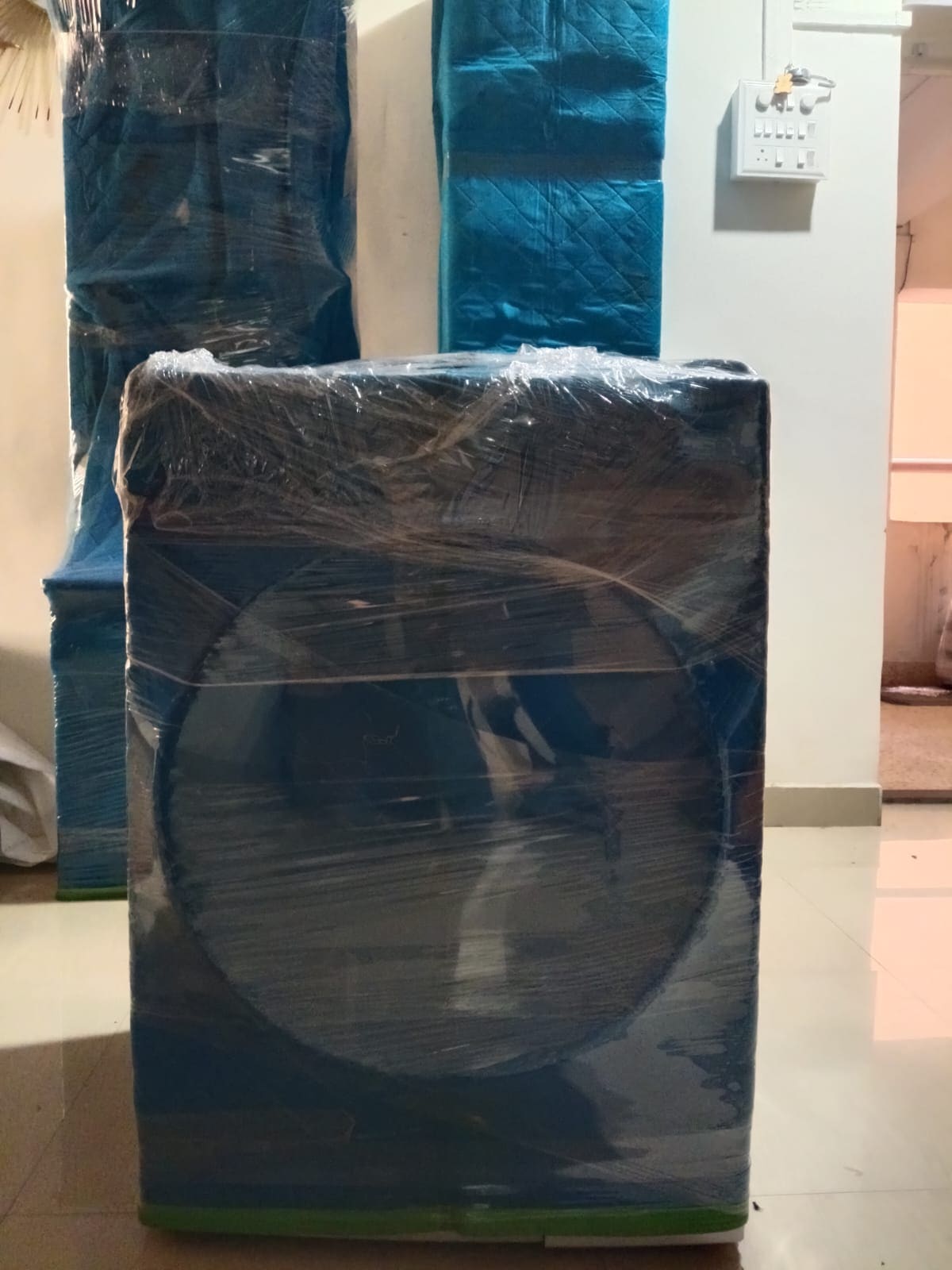 Washing machine wrapped in protective sheeting and stretch film