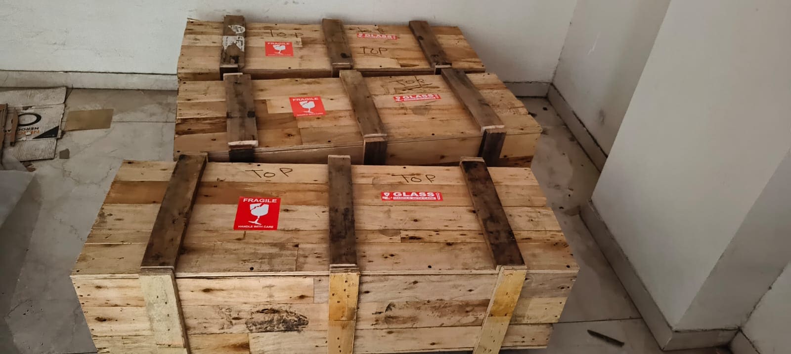 Heavy items packed into timber crates on a floor before transport